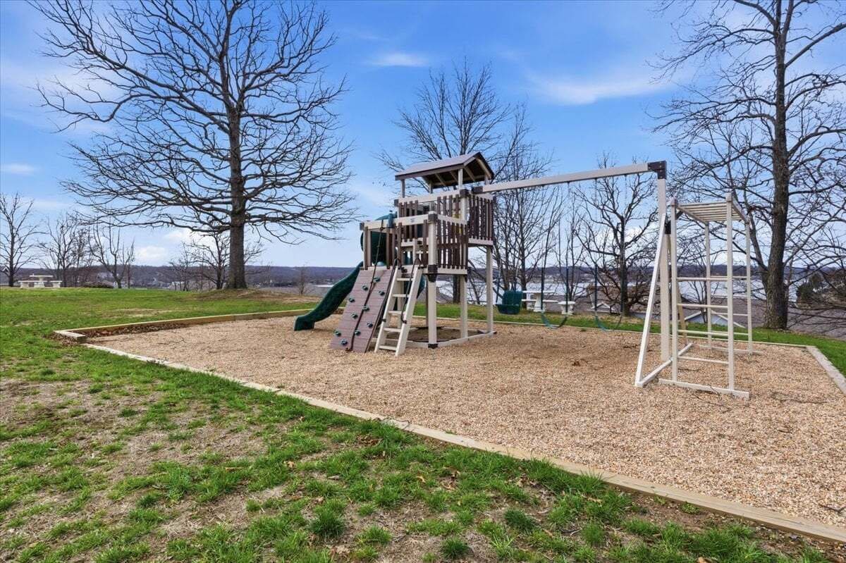 A playground with a slide, climbing structure, and swings.