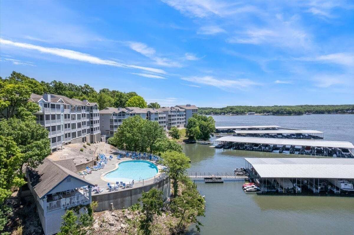 Un resort con piscina, barche ormeggiate e vista sull'acqua.