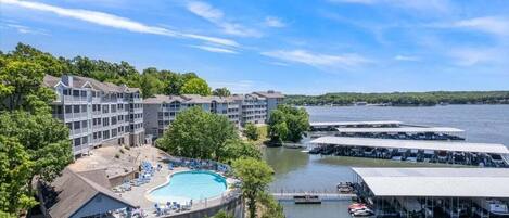 A resort with a swimming pool, docked boats, and a view of the water.