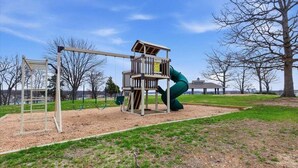 A playground with a slide and climbing structures.