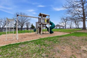 A playground with a slide and climbing structures. - Top Floor Lake Views, Loft Space & Private Deck Retreat at the 12mm (Lake Ozark)