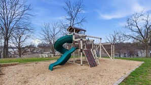 Une aire de jeux avec un toboggan et une structure d’escalade.