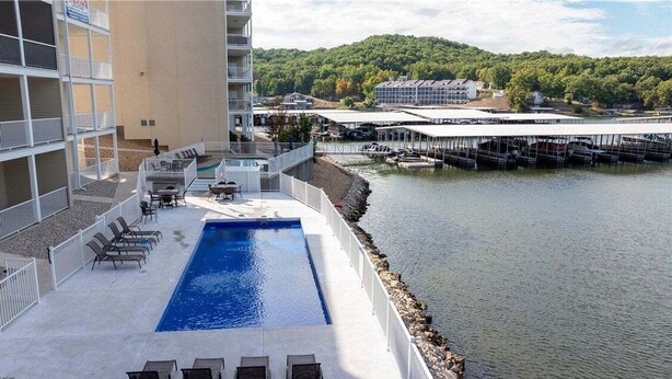 Un espace piscine avec des chaises longues et vue sur l’eau.