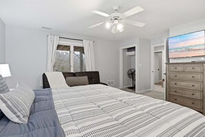 A bedroom with a bed, a ceiling fan, a dresser, and a television. - Lakefront Near Party Cove w/ Dock, Kayaks, Bunk Room & Multi-level Decks (Osage Beach)