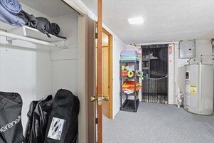 Una habitación con literas, un calentador y un estante con ropa doblada.