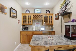 Una cocina con armarios de madera, encimera de granito y un cartel que dice 'JOHN'S'.