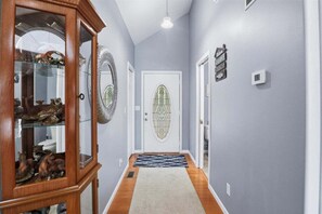 A hallway with a wooden cabinet, a door with a decorative glass panel, and a light fixture. - Private Cove Dock, PWC Lifts, Huge Deck & Family Fun (Climax Springs)