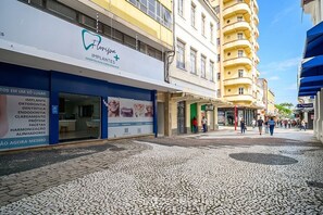 A street with a dental clinic on the left and a multi-story building on the right. - Apt. in Condo w/ City View in Downtown Ubs0502 (Florianópolis)
