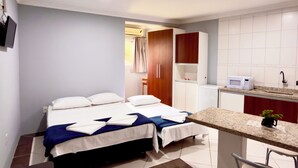 Een hotelkamer met een bed, een bureau, een stoel en een kitchenette.