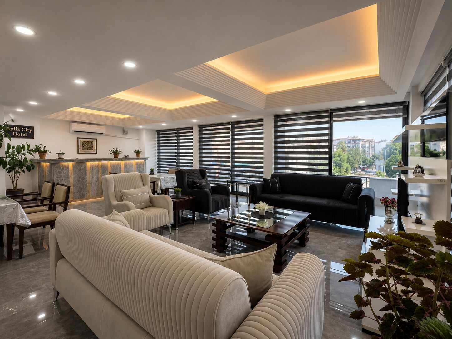 A modern hotel lobby with a sofa, armchairs, a coffee table, and a reception desk.