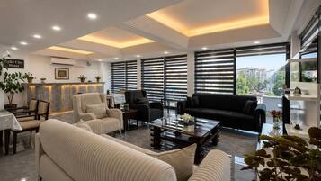 A modern hotel lobby with a sofa, armchairs, a coffee table, and a reception desk.