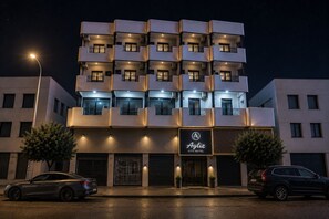 A multi-story hotel with balconies, a sign reading 'Ayliz City Hotel,' and two cars parked in front. - Ayliz City Otel (Manavgat)