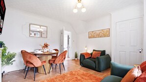 A modern living room with a dining area, a sofa set, and a large mirror. - Crew Comfort Walsall | Sleeps 6 | Fast Wi-Fi (Walsall)