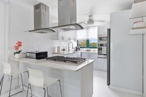 A modern kitchen with a central island, stainless steel appliances, and a view to the outside. - AQUATIKA!!!5 Pools, Hot Tubs, Lazy River, Beach, Tennis, Mini golf, pickleball (Mediania Alta)