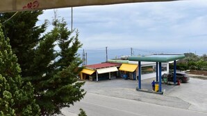A gas station with a canopy, a car, and a person standing by the pump.