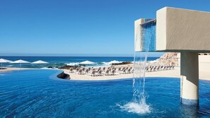 Ein Infinity-Pool mit Blick auf den Ozean, Liegestühle und Sonnenschirme.