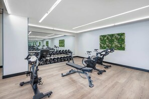A modern gym with cardio machines, free weights, and a mirror wall. - Sway - Pool - Gym - Mins to Broadway (Nashville)