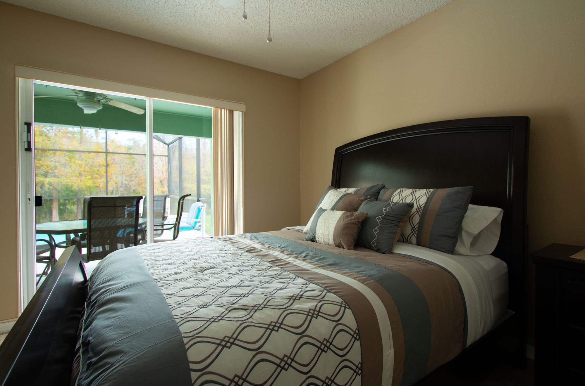 A bedroom with a large bed, a window, and a chair.