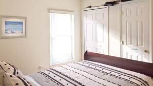 Ein Schlafzimmer mit einem Bett, einer Tür und einem Fenster.