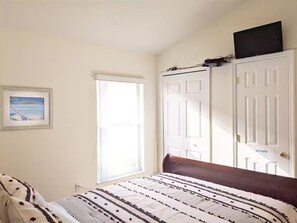 Ein Schlafzimmer mit einem Bett, einer Tür und einem Fenster.