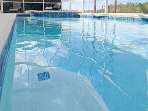 A clear swimming pool with a tiled edge and a view of the surrounding area. - Newly Remodeled Home with a Private Pool and Hot Tub, Right Next to Disney! (Davenport)