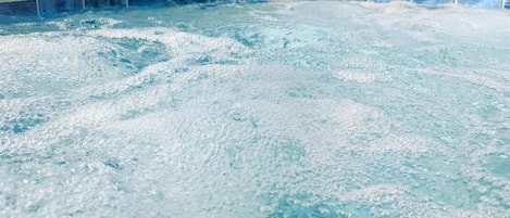 A hot tub with visible bubbles and a tiled edge.