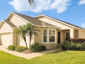 A single-story house with a garage, a front porch, and a well-maintained lawn. - Newly Remodeled Home with a Private Pool and Hot Tub, Right Next to Disney! (Davenport)