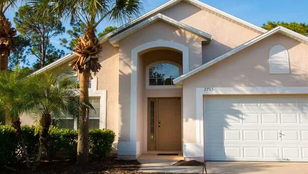 A single-story house with a garage, a front door, and a small porch. - 4Bed/3Bath Perfect Location, Perfect Home (Kissimmee)