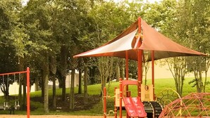 A playground with a red canopy, swings, and slides. - 4Bed/3Bath Perfect Location, Perfect Home (Kissimmee)