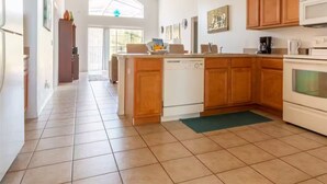 A kitchen with wooden cabinets, a dishwasher, a microwave, and a large window. - 4Bed/3Bath Perfect Location, Perfect Home (Kissimmee)