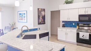 A kitchen with a granite countertop, white cabinets, a dishwasher, and a stainless steel oven. - 4Bed/3Bath Sunny Lakeview Escape (Davenport)