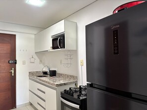 Eine moderne Küche mit integriertem Mikrowellenherd, Herd und Kühlschrank.