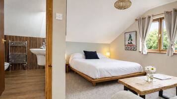 A bedroom with a bed, bedside table, and a window with curtains.