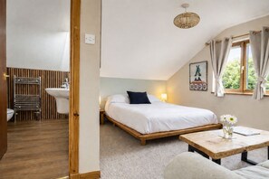 A bedroom with a bed, bedside table, and a window with curtains. - CRAGMHOR (Balquhidder)