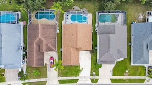 Um bairro residencial com várias casas, cada uma com um estilo de telhado diferente e piscina.