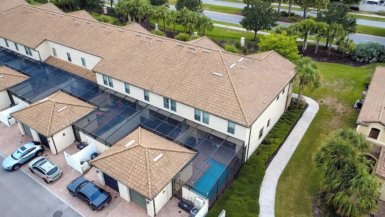 A multi-story residential building with a swimming pool, covered parking, and a well-maintained lawn.