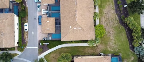 Un quartier résidentiel comprenant plusieurs maisons, une route et une piscine.