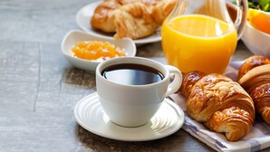 A breakfast setting with croissants, orange juice, and coffee.