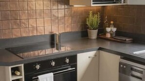 Una cucina moderna con forno a incasso, microonde e lavastoviglie in acciaio inossidabile.