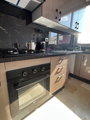 A modern kitchen with a gas stove, oven, and stainless steel appliances. - Luxury Stay (Casablanca)