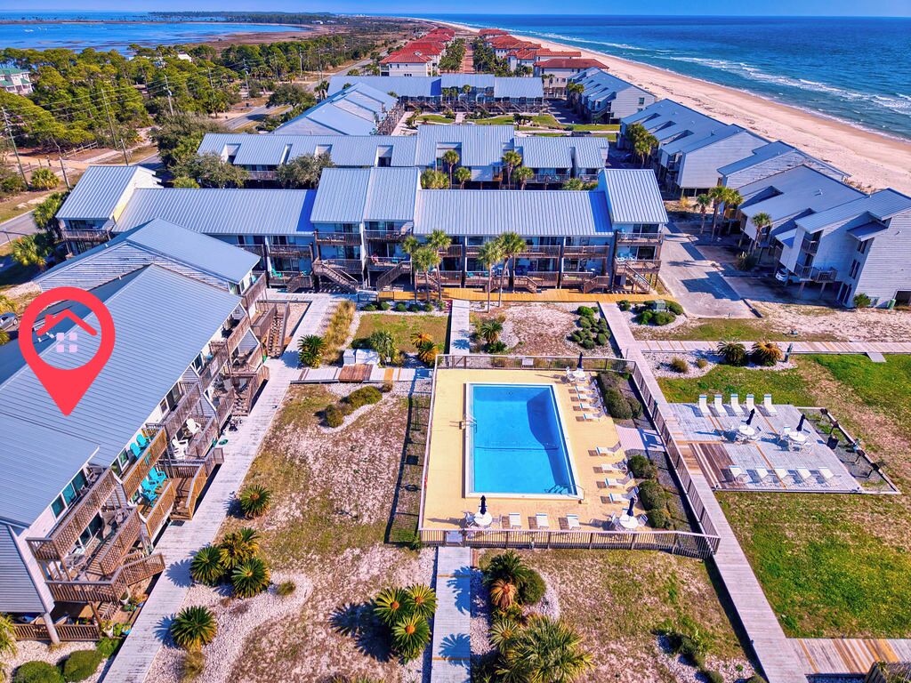 Ein Resort mit mehreren Gebäuden, einem Swimmingpool und Blick auf den Strand.