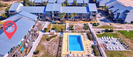 Ein Resort mit mehreren Gebäuden, einem Swimmingpool und Blick auf den Strand.