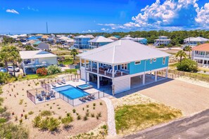 A coastal property with a large pool, multiple decks, and a view of the surrounding neighborhood. - Gulf Watch! Across street from beach, private pool, elevator, and more! (St. George Island)