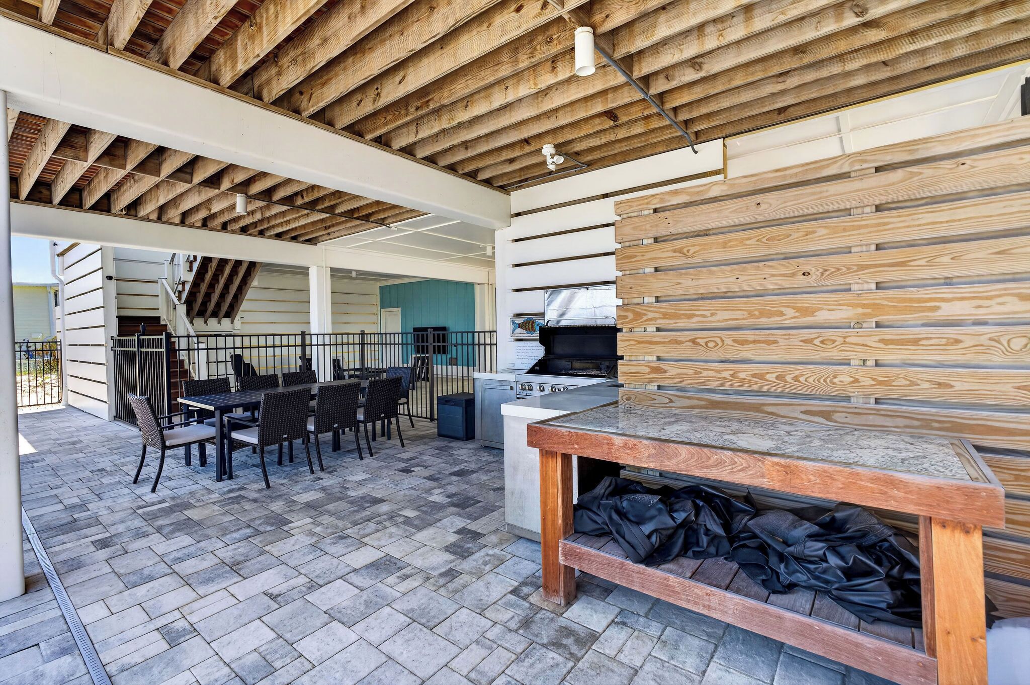 An outdoor patio with a grill, seating area, and a view of the house.