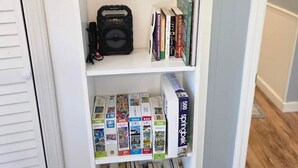 Ein Bücherregal mit verschiedenen Gegenständen, darunter Bücher, eine Kamera und Reinigungsprodukte.