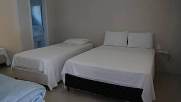 Una habitación de hotel con dos camas, un baño y una mesita.