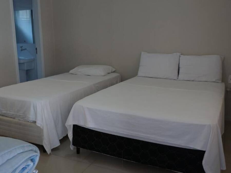 Ein Hotelzimmer mit zwei Betten, einem Badezimmer und einem kleinen Tisch.