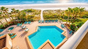 Ein Poolbereich mit Blick auf Strand und Meer.