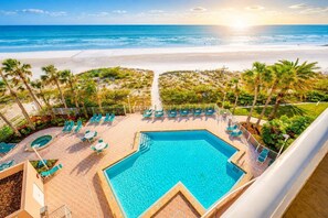 Ein Poolbereich mit Blick auf Strand und Meer.