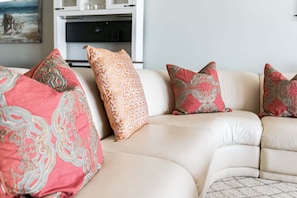 A beige sofa with patterned cushions in a living room. - CBC 2-6D - 2BR/2.5BA Gulf-view condo in Clearwater Beach, on Sand Key. (Clearwater Beach)